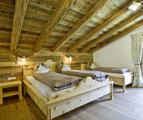 Schlafzimmer mit Doppelbett und Einzelbett auf der Martenalm