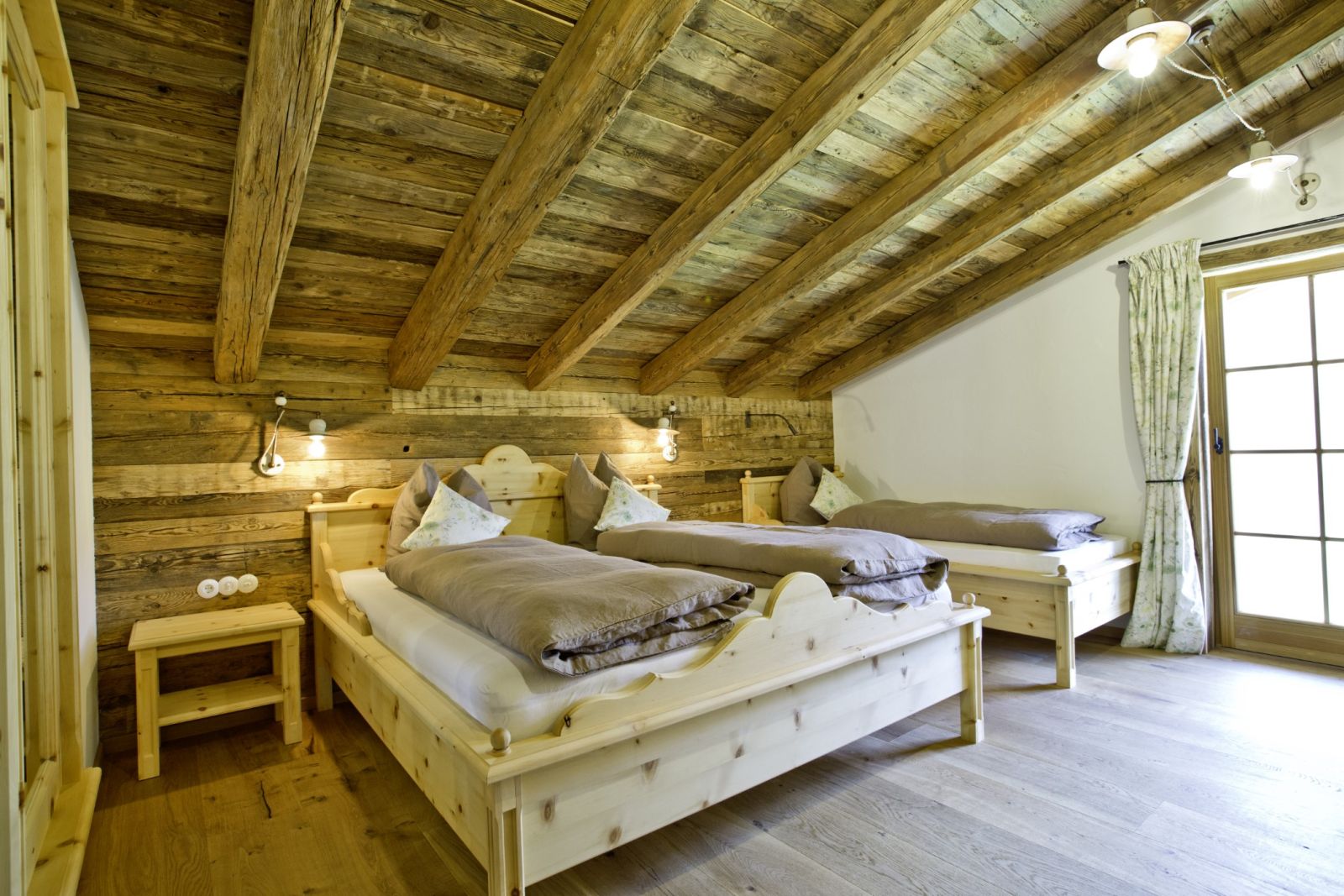 Schlafzimmer mit Doppelbett und Einzelbett auf der Martenalm