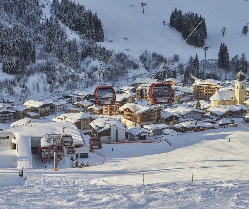 Verschneite Häuser und Skipisten in Hinterglemm