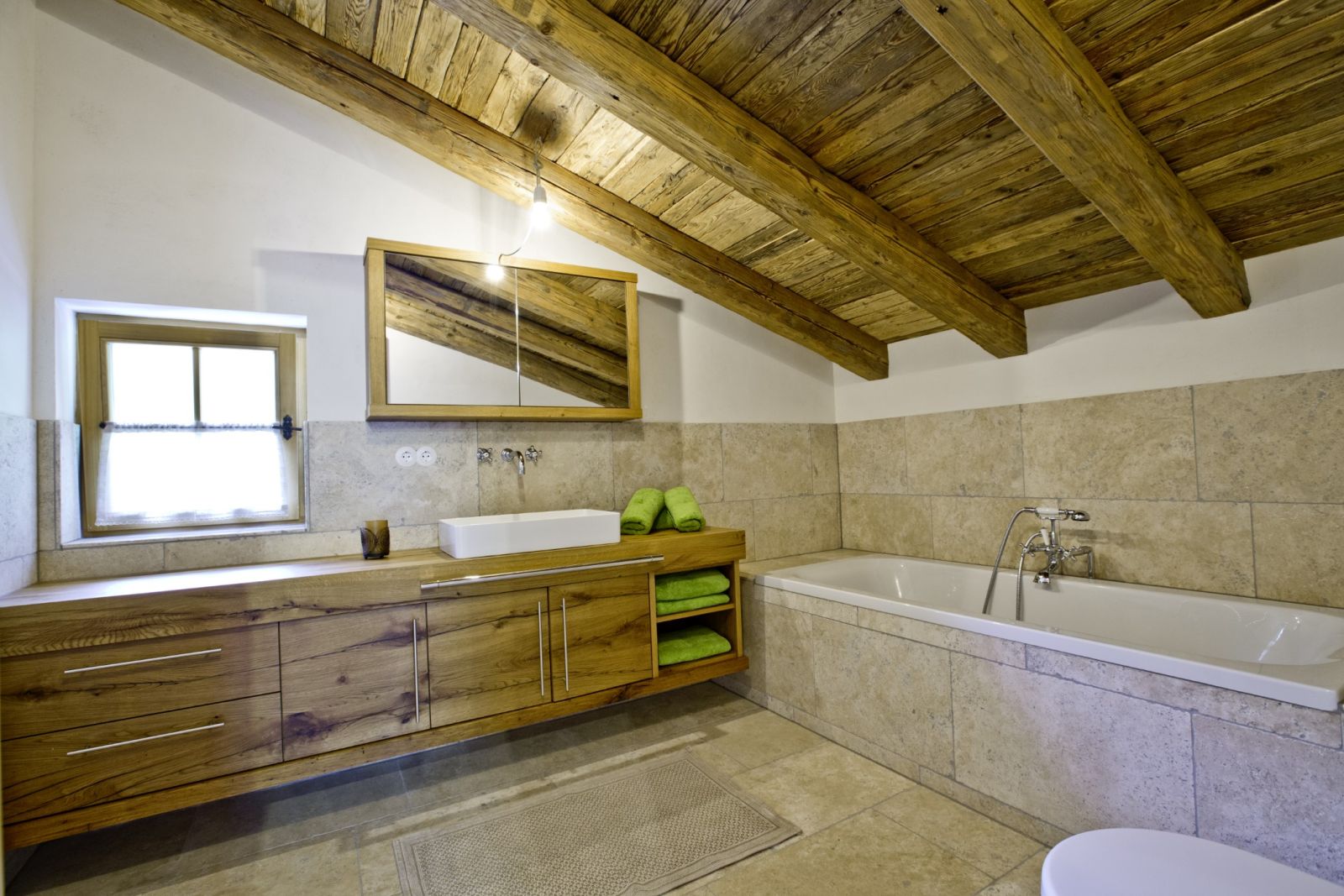 Badezimmer mit Badewanne und Holzwaschtisch auf der Martenalm